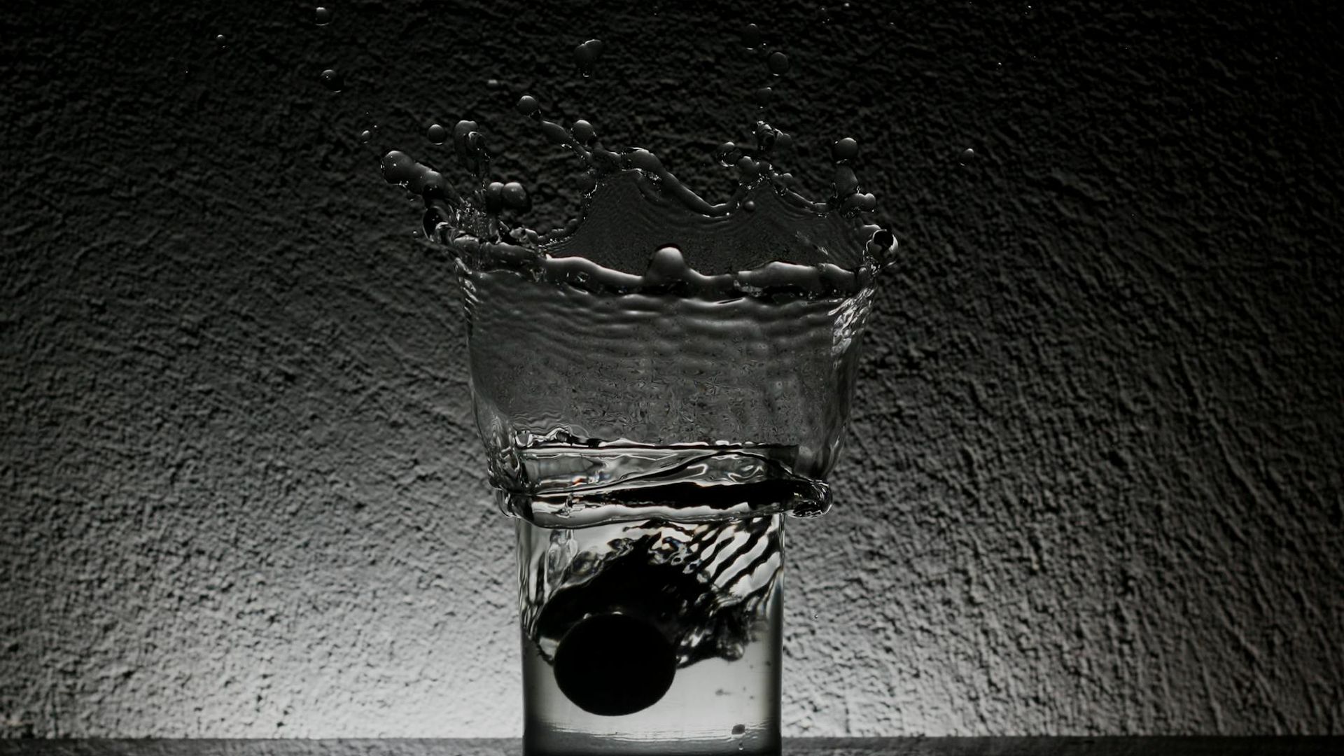 A person in a dynamic, fluid motion pose in a dark, minimalist space.